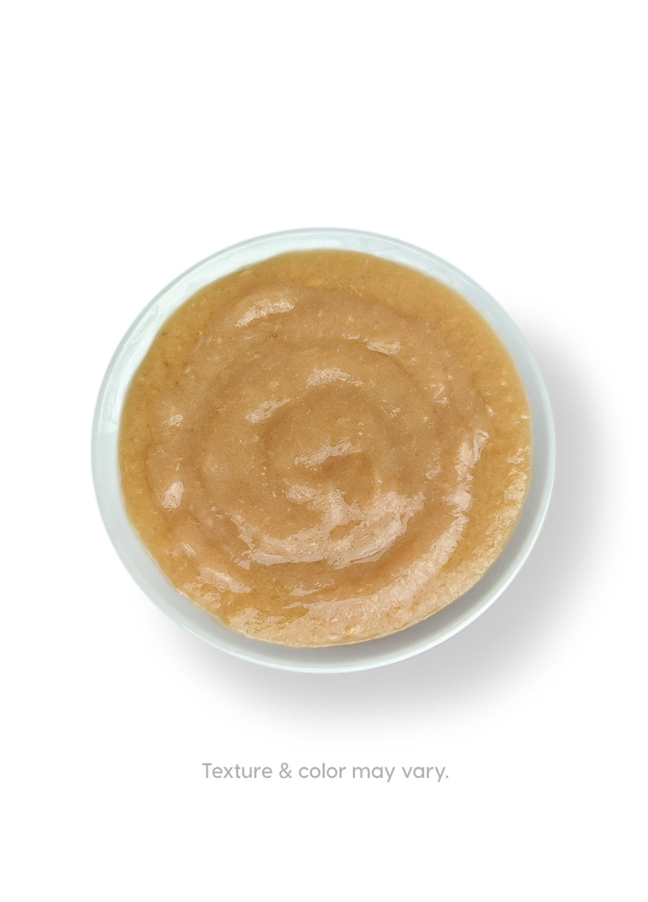 Creamy chicken bone broth in a white bowl with a smooth, light brown texture.