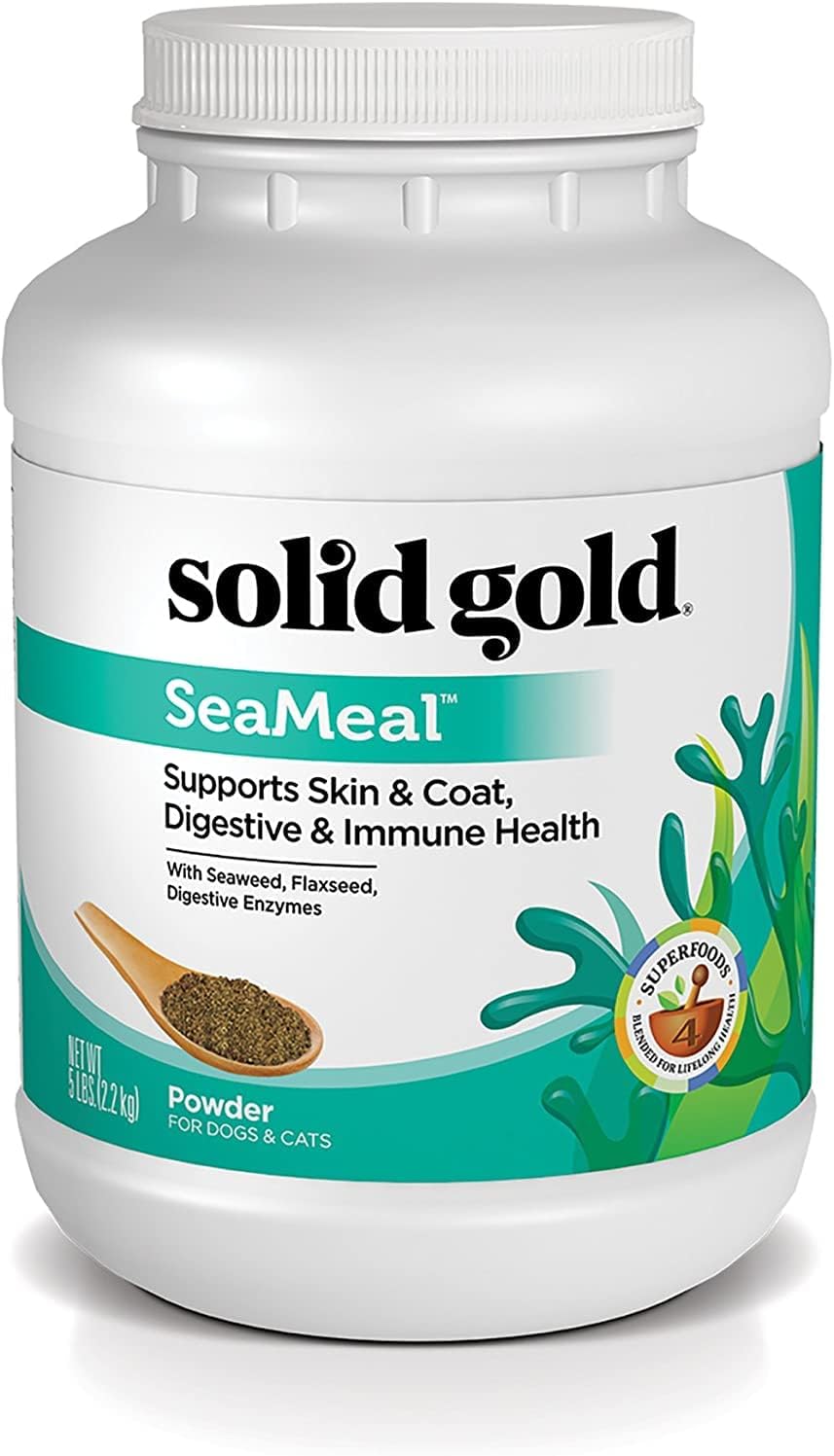 White container of SeaMeal™ supplement powder for dogs and cats, featuring a green label and a wooden spoon with powder.