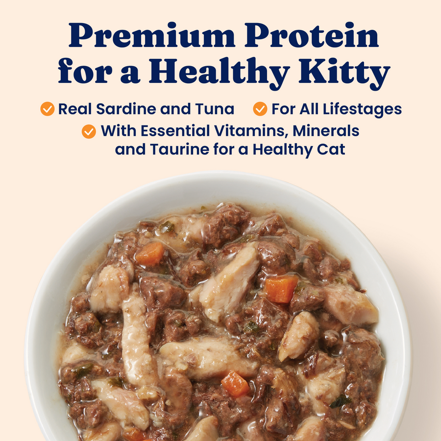 Wet cat food in a bowl featuring chunks of sardine, tuna, and vegetables in a gravy-like sauce.