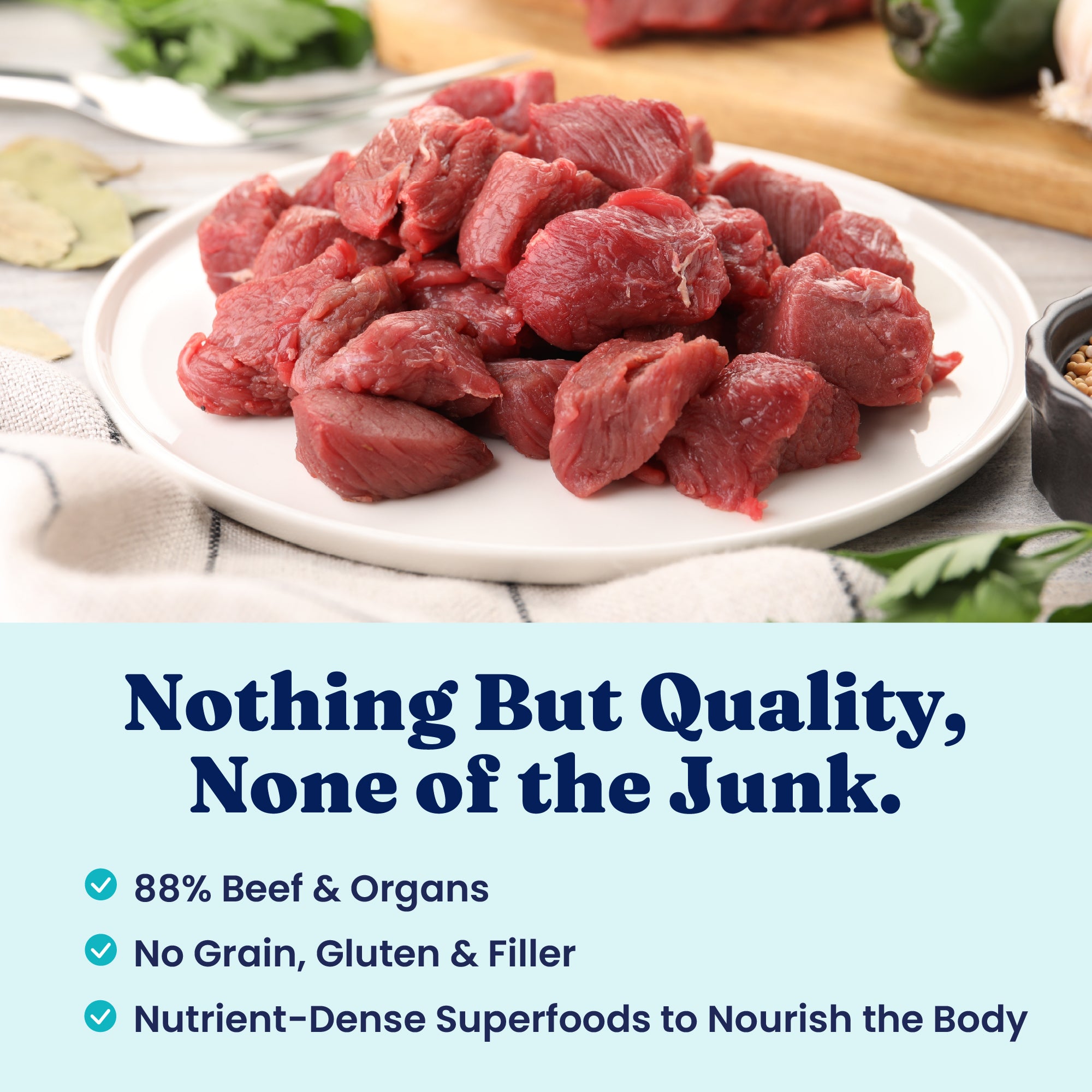 Raw, freeze-dried beef chunks arranged on a white plate, with herbs and spices in the background.